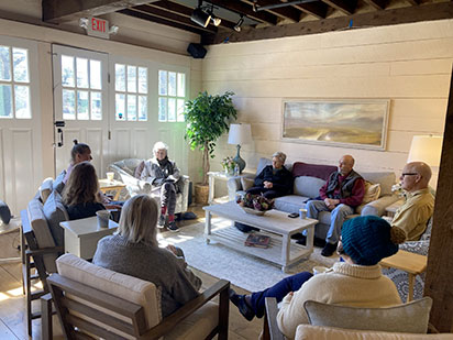 photo of mixed age adults in a living room participating in a group discussion